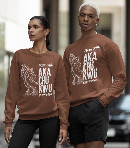 Two people wearing matching brown sweatshirts with text on a city street.