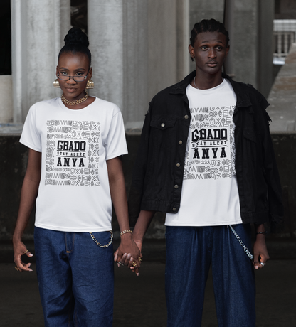 Two people wearing matching white t-shirts with text, standing in front of classical architecture.