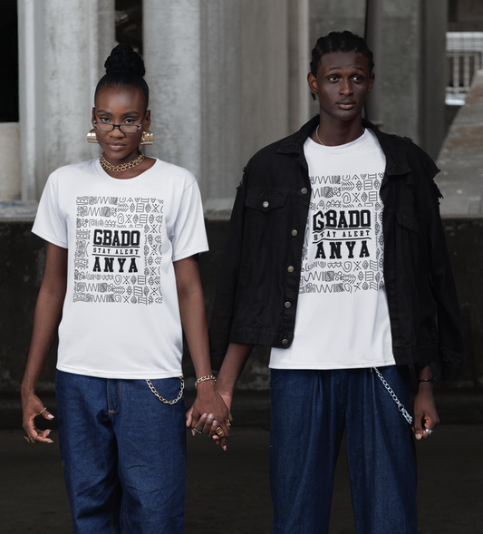 Two people wearing matching white t-shirts with text, standing in front of classical architecture.