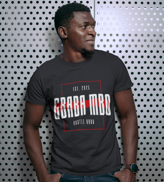 Man wearing a dark gray t-shirt with text against a patterned wall