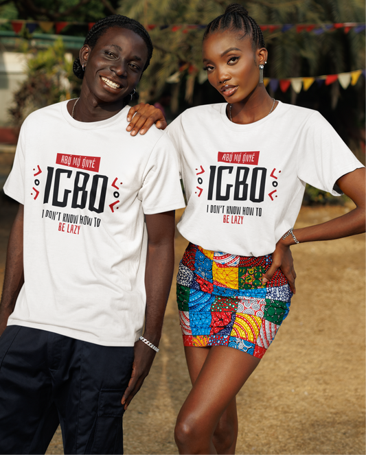 Two people wearing white t-shirts with 'IGBO' text, standing outdoors with greenery in the background.