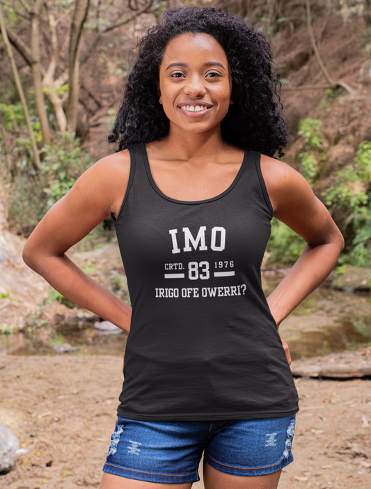 Woman wearing a black tank top with text standing in a forest setting
